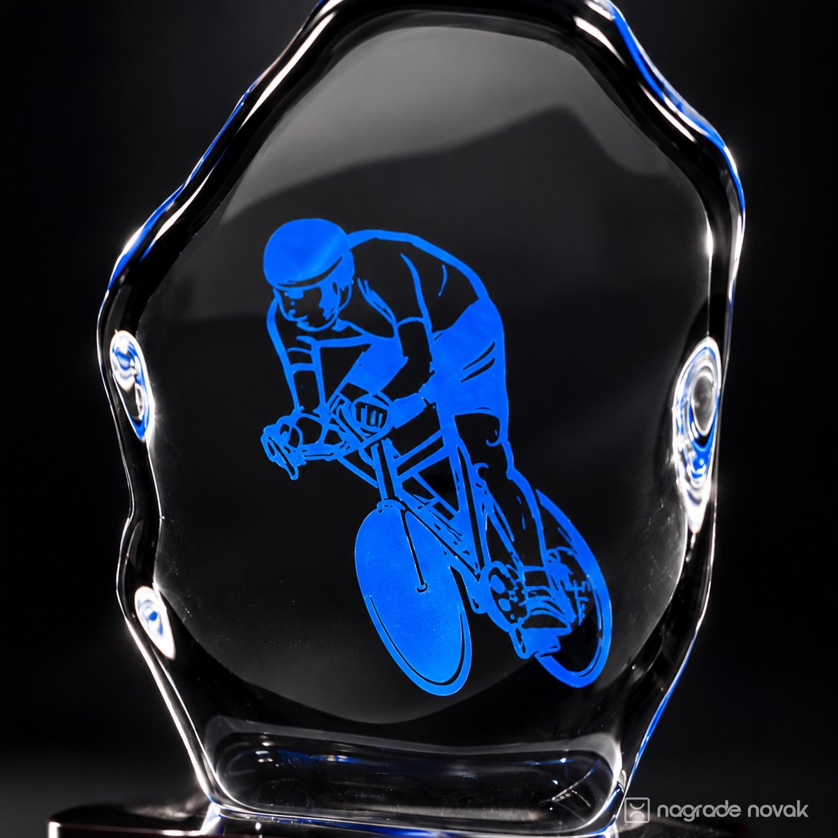 Close-up of the glass award with the blue racing cyclist graphic and glowing rounded edges