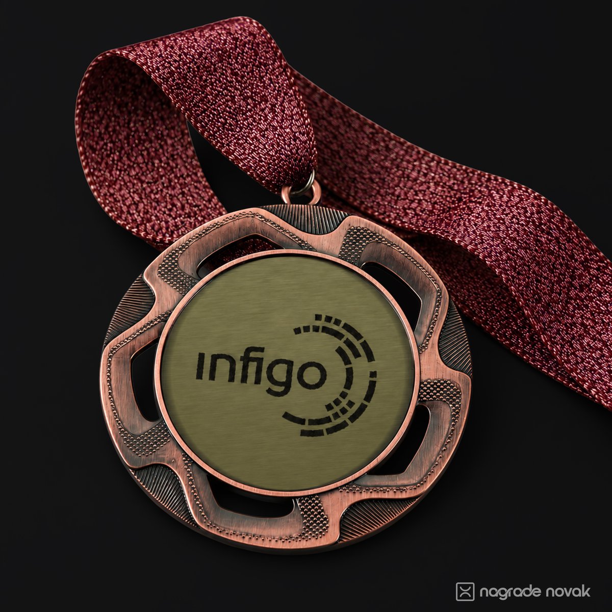 Bronze medal with the black Infigo logo on a gold insert, hanging from a burgundy glitter ribbon on a dark background