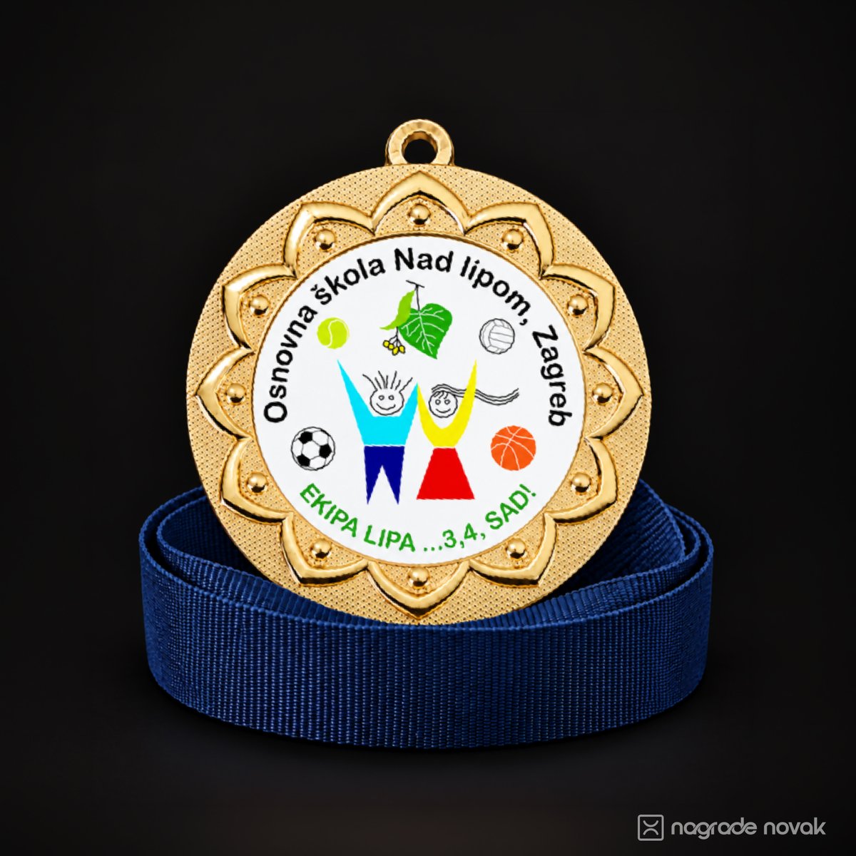 Gold medal with a petal-shaped embossed border and a white front insert showing the school logo, “Osnovna škola Nad lipom, Zagreb” and the motto “Ekipa Lipa ...3,4, SAD!”, standing on a coiled blue ribbon on a dark background