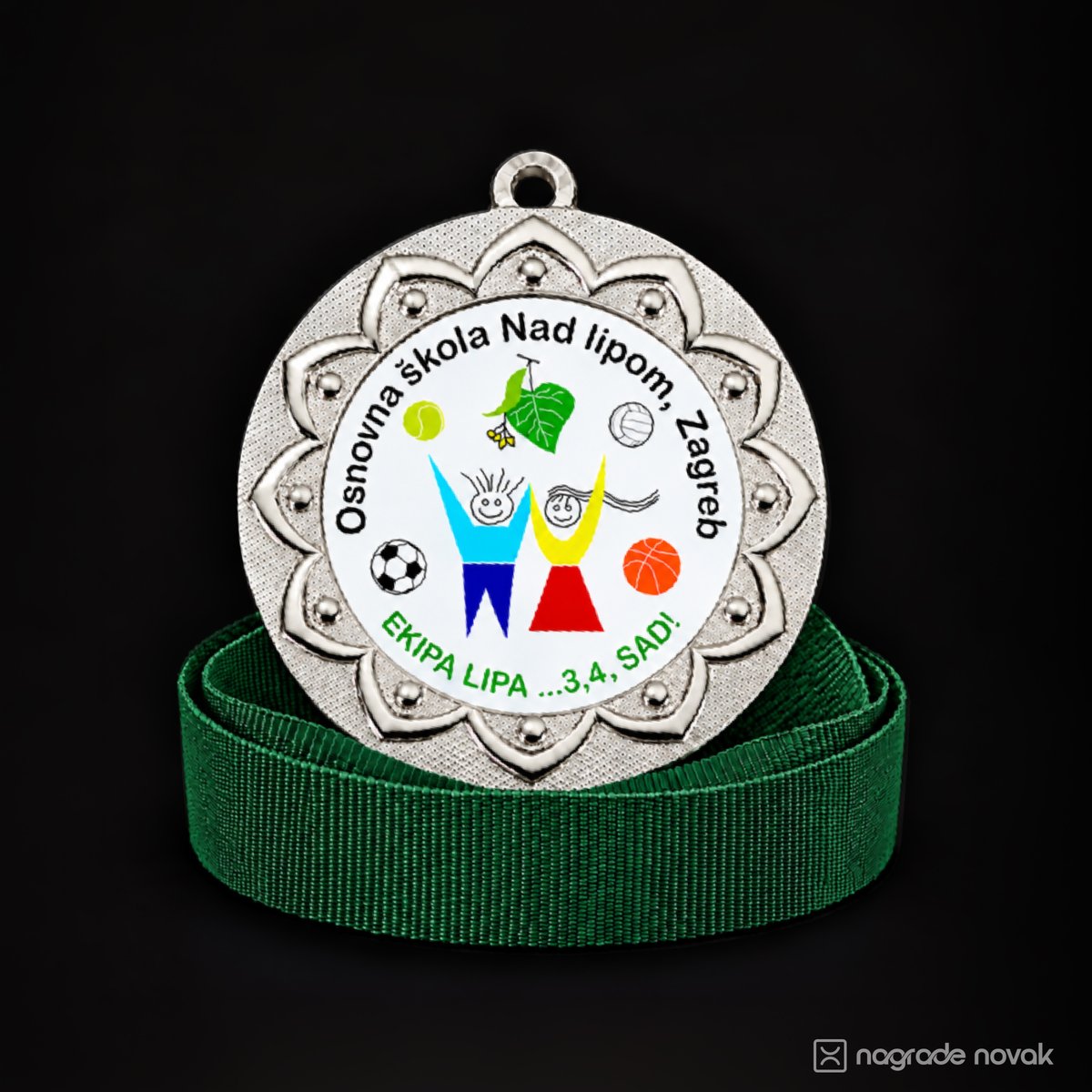 Silver medal with a petal-shaped embossed border and a white front insert showing the school logo, “Osnovna škola Nad lipom, Zagreb” and the motto “Ekipa Lipa ...3,4, SAD!”, standing on a coiled green ribbon on a dark background