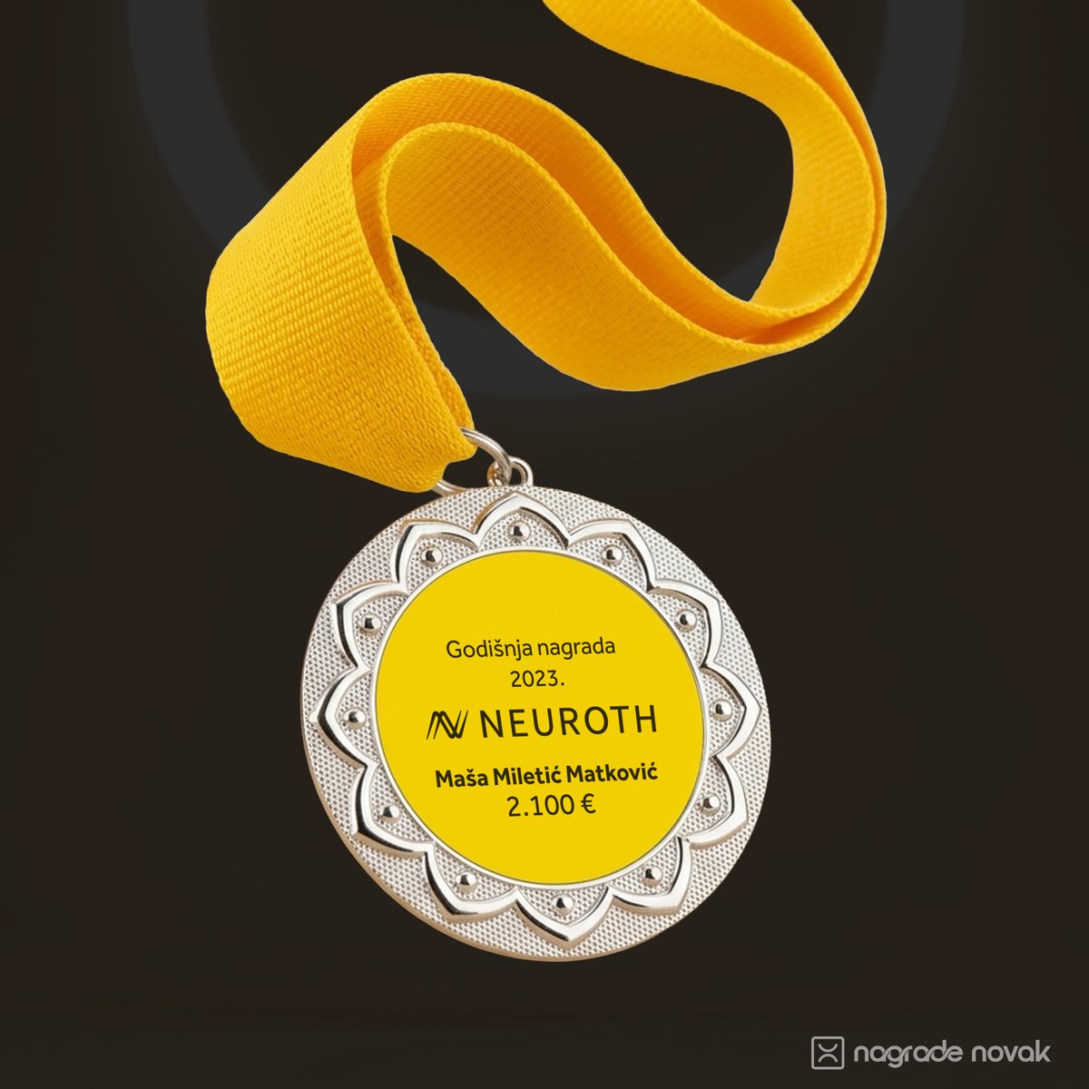 Silver medal with a yellow Neuroth insert hanging from a twisted yellow ribbon on a dark background