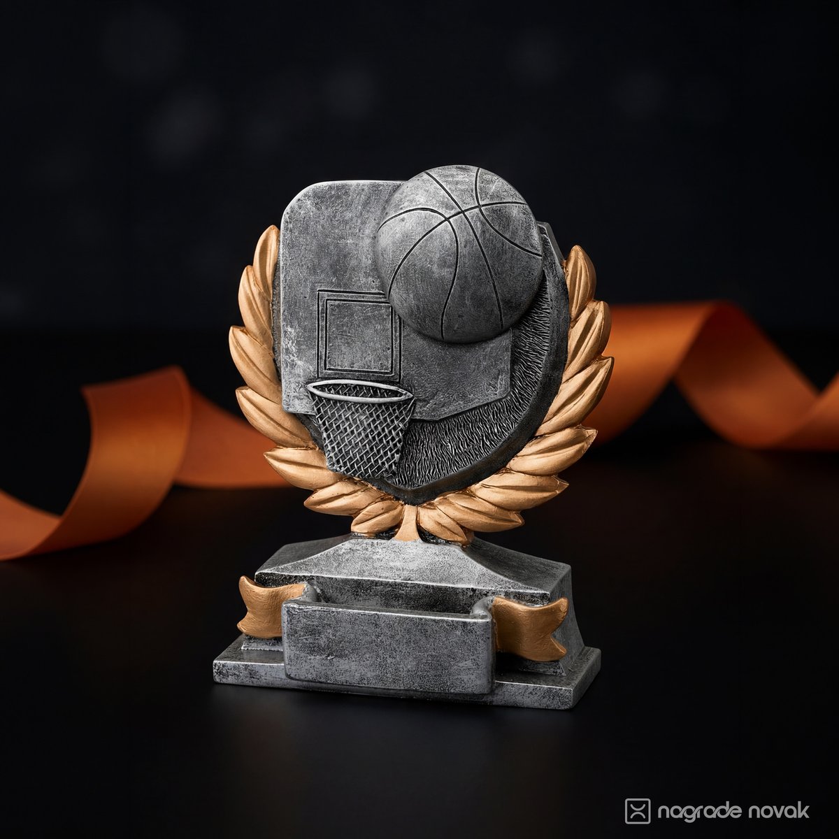 Silver-grey basketball statue with a hoop, laurel wreath and bronze ribbon on a stepped base, with an orange ribbon behind