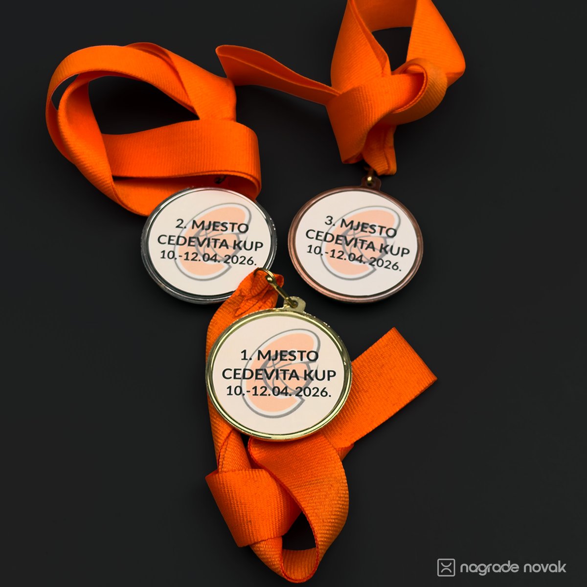 Three round medals printed with 1st, 2nd and 3rd place and the Cedevita Cup 10.-12.04.2026 dates, on orange ribbons