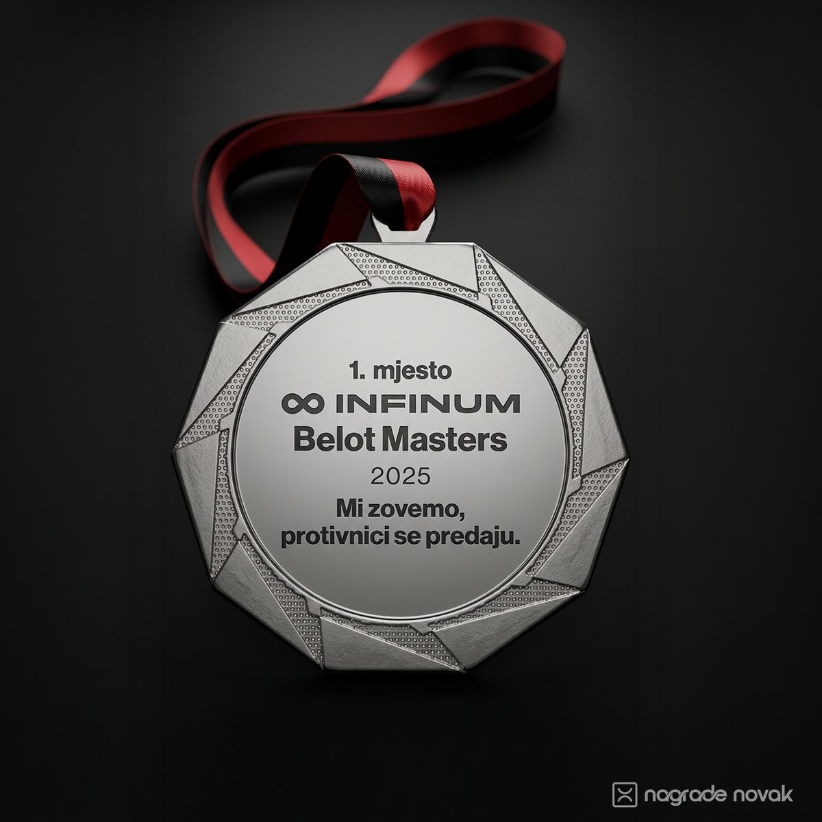 Front view of a silver medal with an angular edge and a red and black ribbon on a dark background.