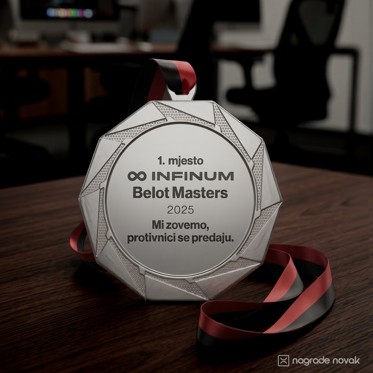 Angular-edged silver medal with a red and black ribbon resting on a wooden office desk.