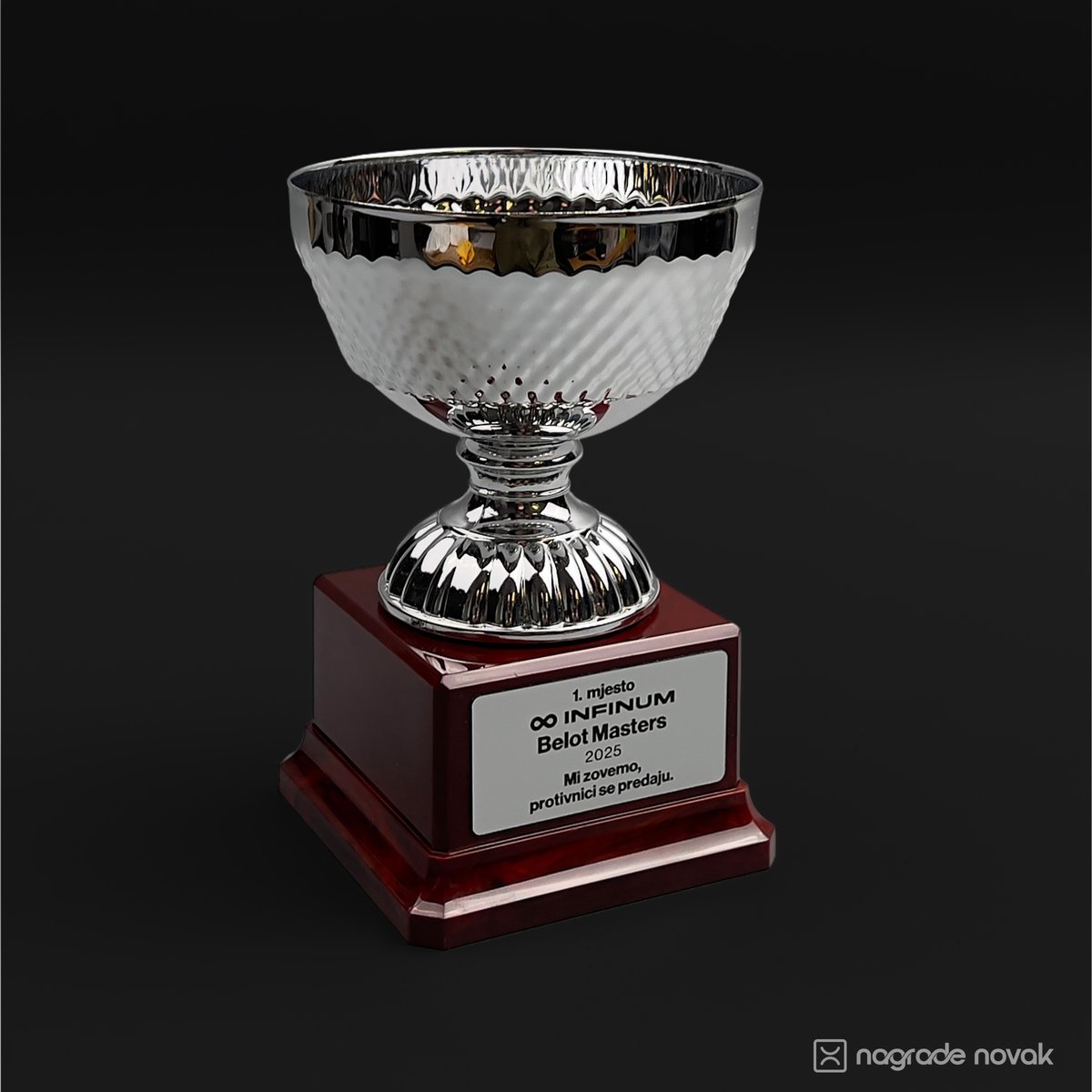 Front view of a silver trophy cup on a dark red acrylic base with a metal plate.
