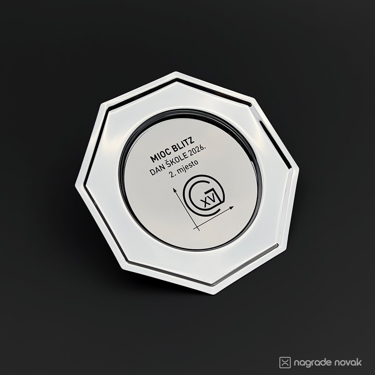 Octagonal silver plate award with a round silver insert reading "MIOC BLITZ, DAN ŠKOLE 2026., 2. mjesto" with the school logo, on a dark background