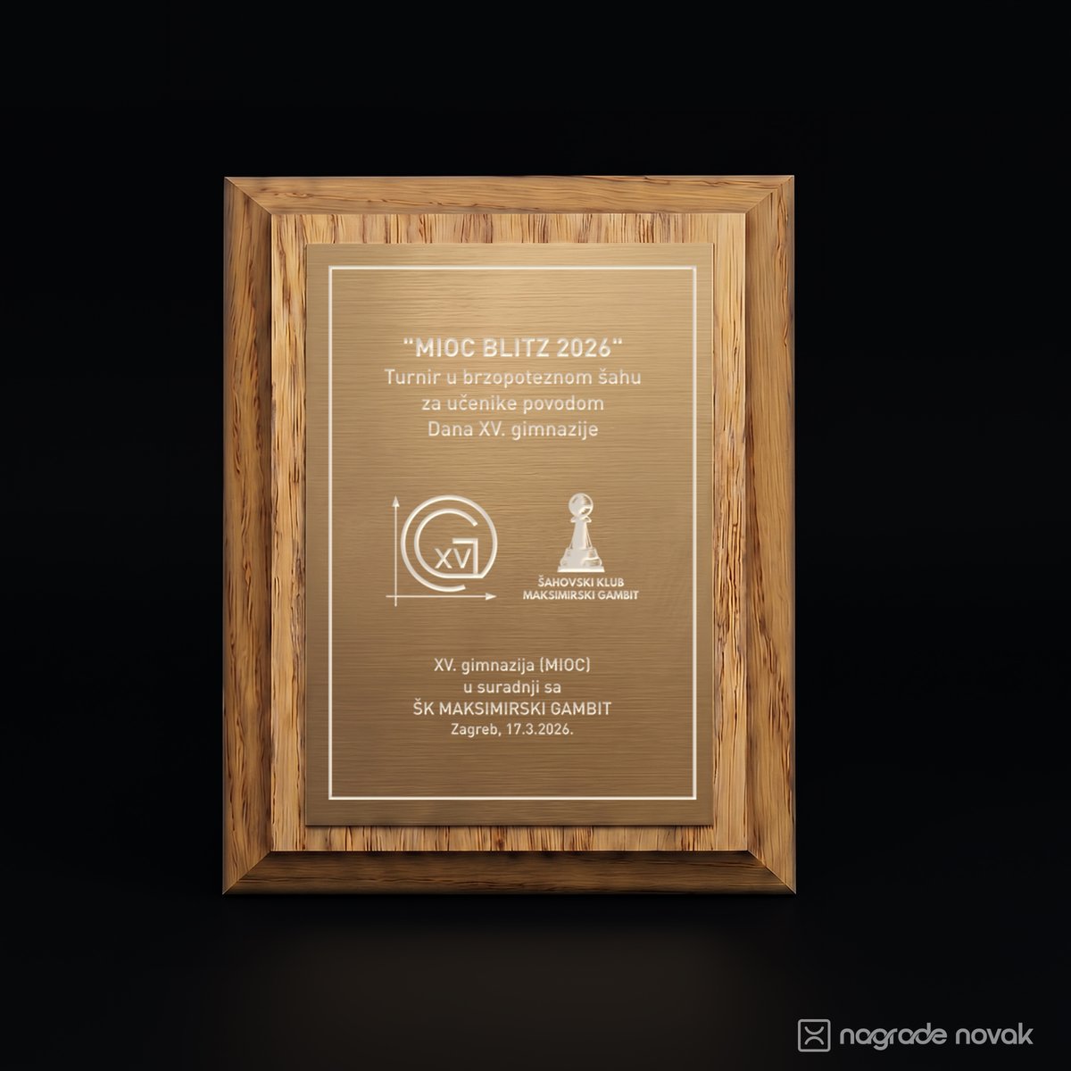 Light wood organiser award with a bronze plate engraved with the "MIOC BLITZ 2026" tournament text, the school logo and the Šahovski klub Maksimirski gambit logo, on a dark background