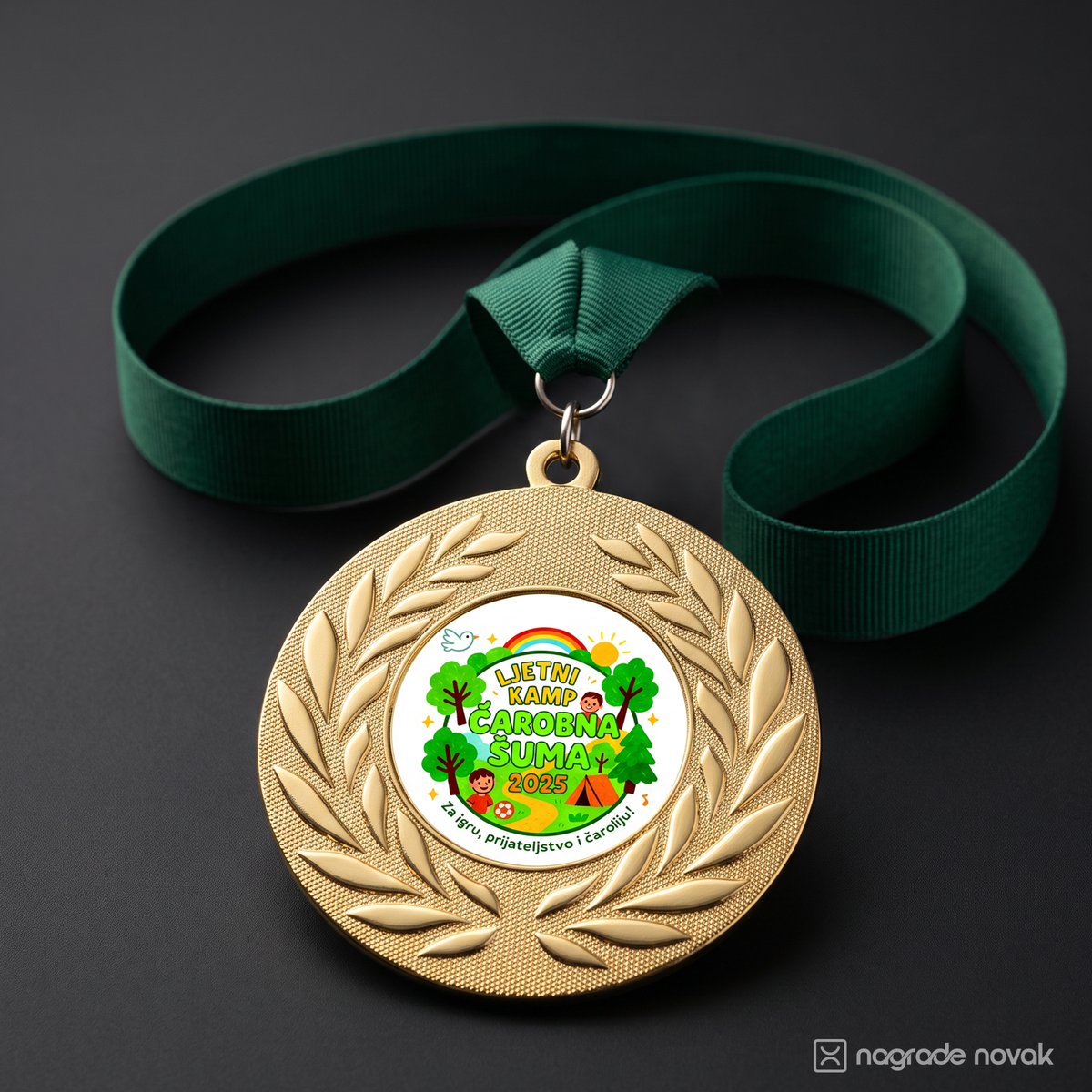 Gold medal with a laurel wreath and the camp insert on a dark green ribbon, lying on a dark grey surface