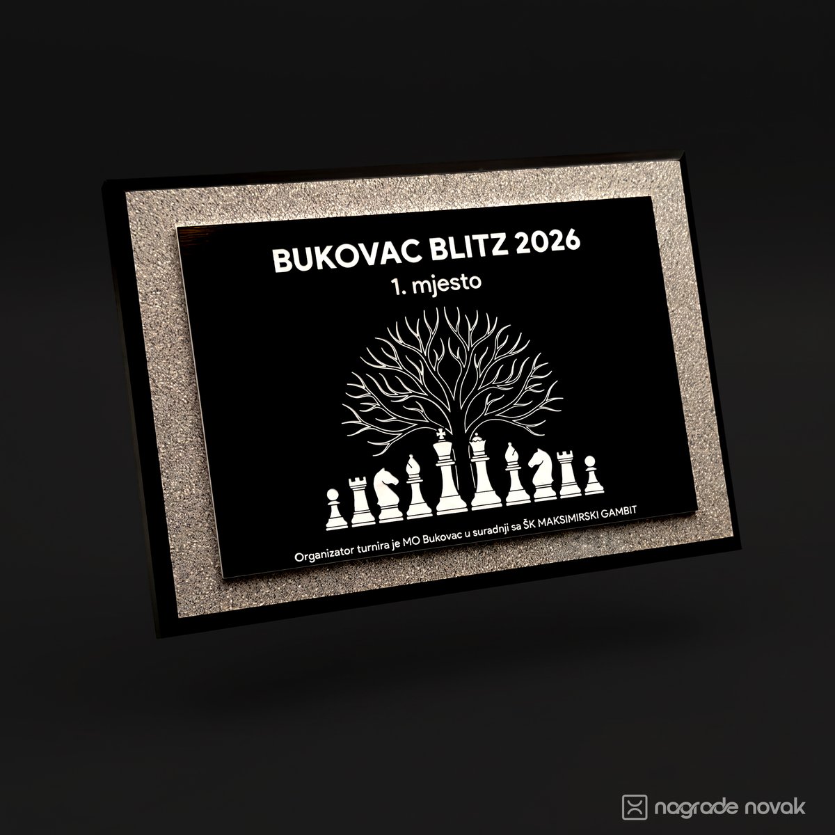 Award plaque with a brushed black plate engraved "BUKOVAC BLITZ 2026, 1. mjesto" with a tree above chess pieces, in a grey textured frame with a black edge, on a dark background