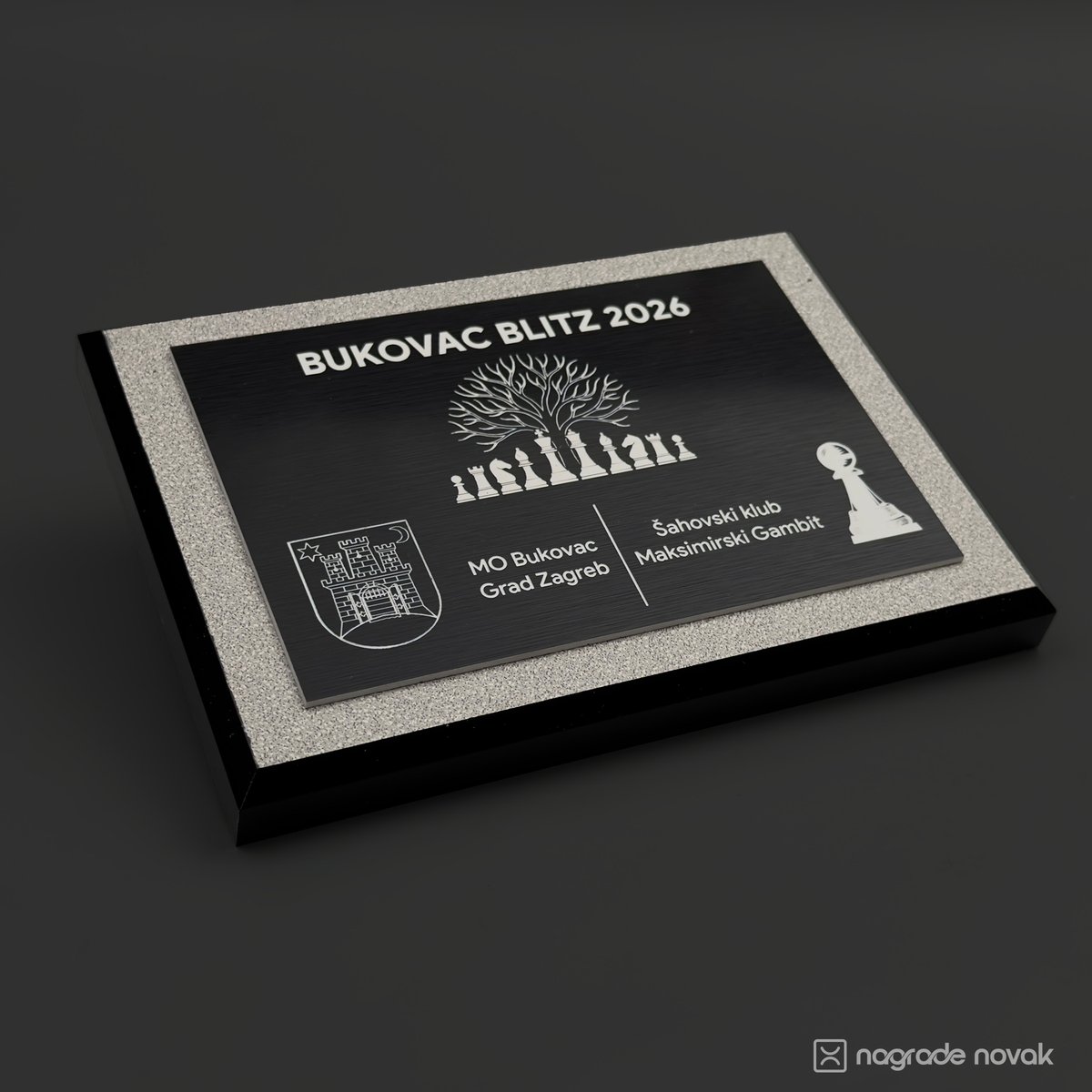 Organiser plaque engraved "BUKOVAC BLITZ 2026" with a tree above chess pieces and the logos of MO Bukovac, Grad Zagreb and Šahovski klub Maksimirski Gambit, seen at an angle
