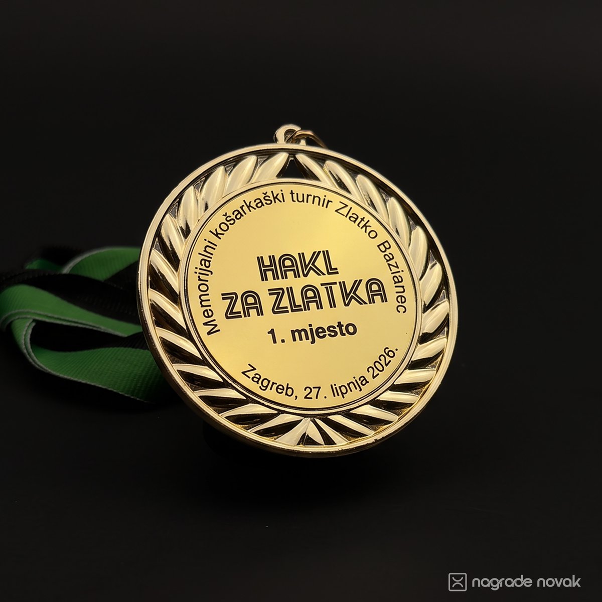 Gold medal with a relief laurel wreath, engraved "HAKL ZA ZLATKA, 1. mjesto, Zagreb, 27. lipnja 2026.", on a green and black ribbon against a dark background