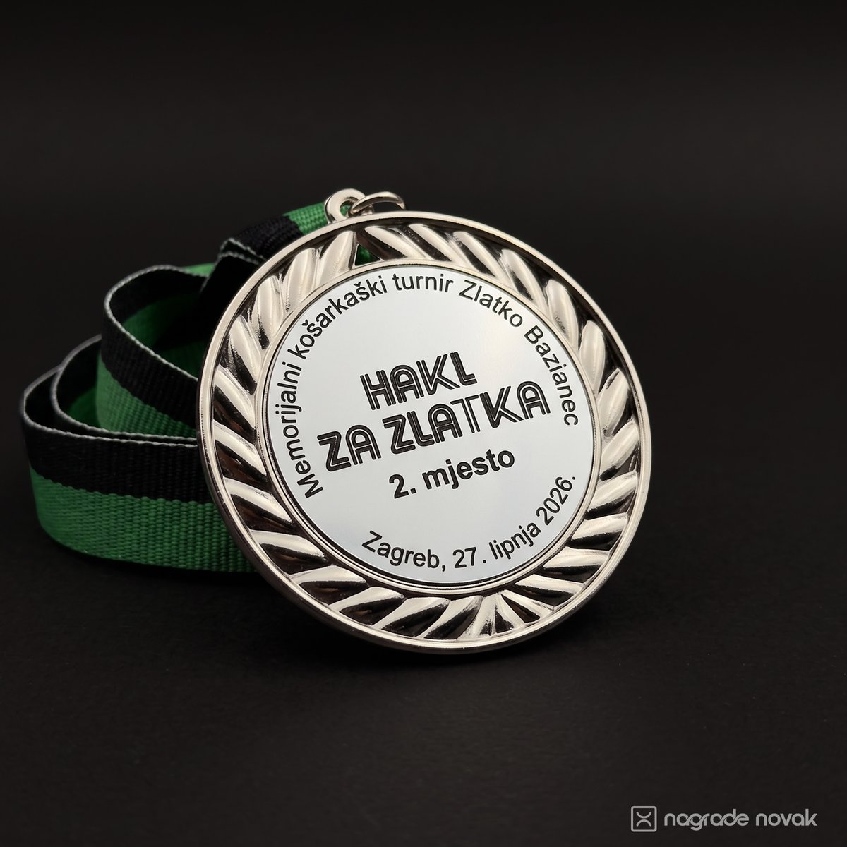 Silver medal with a relief laurel wreath, engraved "HAKL ZA ZLATKA, 2. mjesto, Zagreb, 27. lipnja 2026.", on a green and black ribbon against a dark background