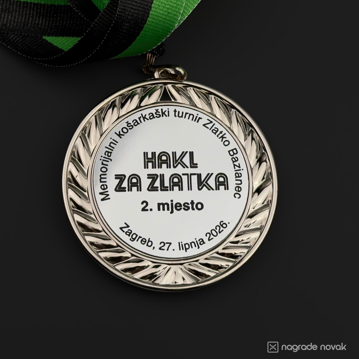 Close-up of the silver 2nd place medal with laurel wreath and engraved "HAKL ZA ZLATKA" text, with a green and black ribbon